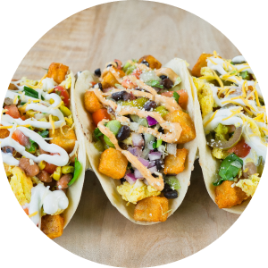 Uberrito Mexican franchise three flavorful Mexican tacos with toppings beautifully presented on a wooden board