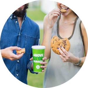 A man and woman eating cookies and a cup of coffee from Uberrito Mexican franchise