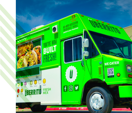 An Uberrito Mexican food truck franchise parked in front of a building.