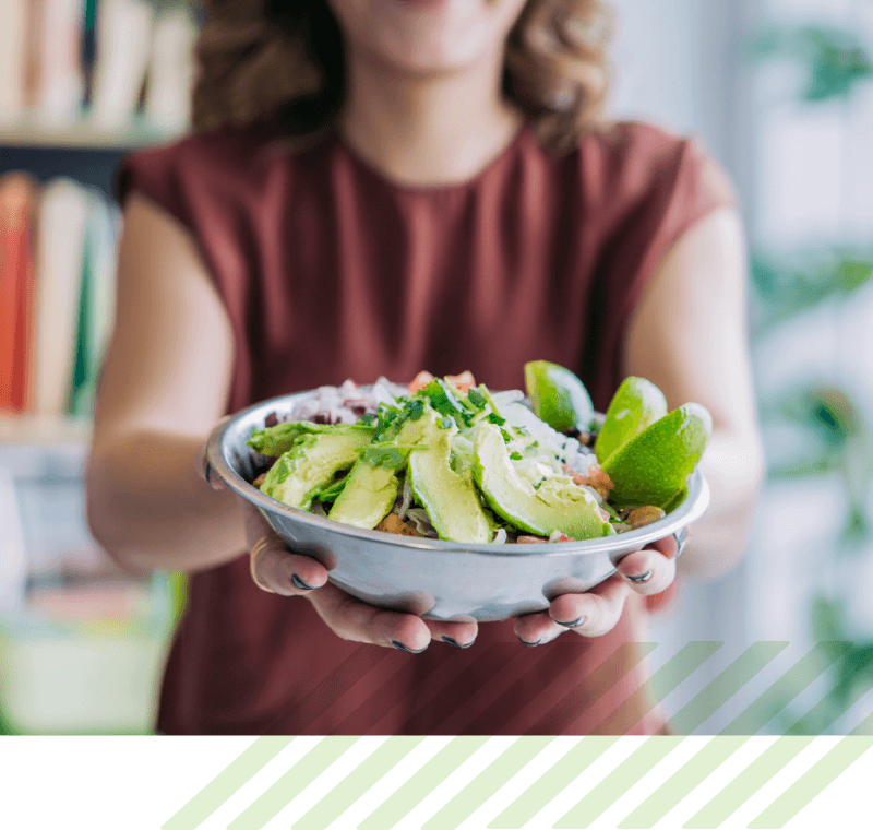 A woman holding a bowl of salad.